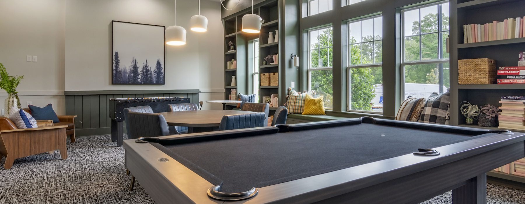 a game room with a pool table, tables and chairs